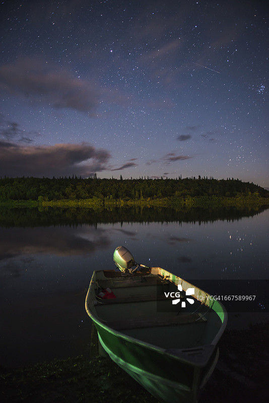 夜晚，在阿拉斯加西南部的布里斯托尔湾地区，一艘小船停靠在奎恰克河岸边。图片素材