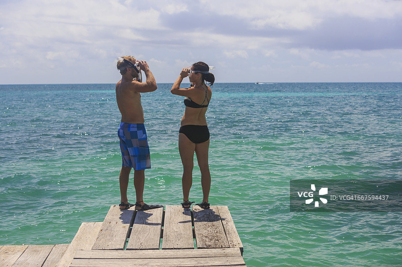 情侣在圣乔治岛礁度假村的木制码头上浮潜（浮潜用具）图片素材