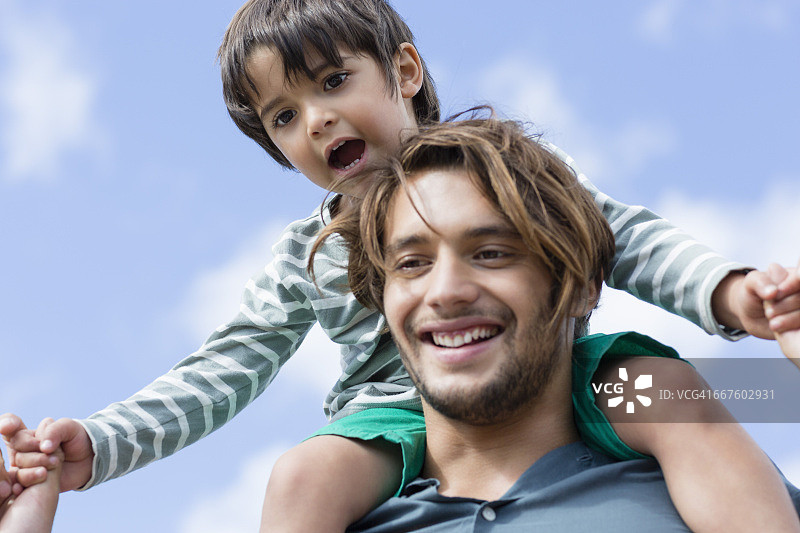 快乐的男人扛着儿子在肩上特写图片素材