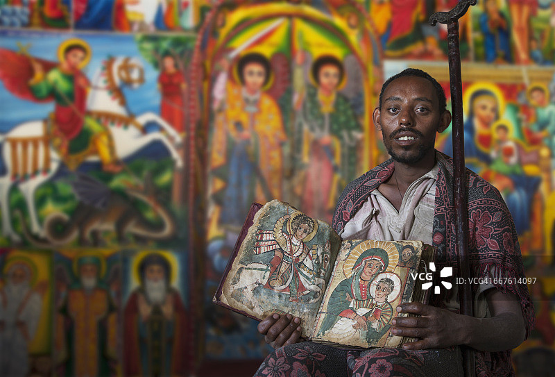 在埃塞俄比亚东正教修道院中，牧师展示一本古老的宗教书籍图片素材