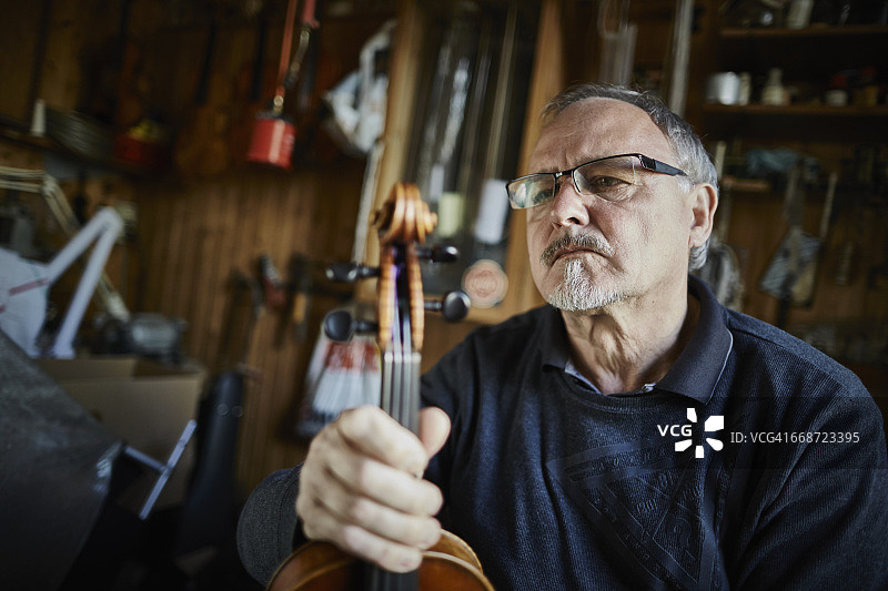 制琴师在工作室检查小提琴图片素材