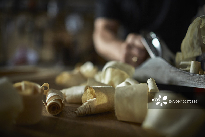 制琴师在工作台上刨平木材的特写图片素材