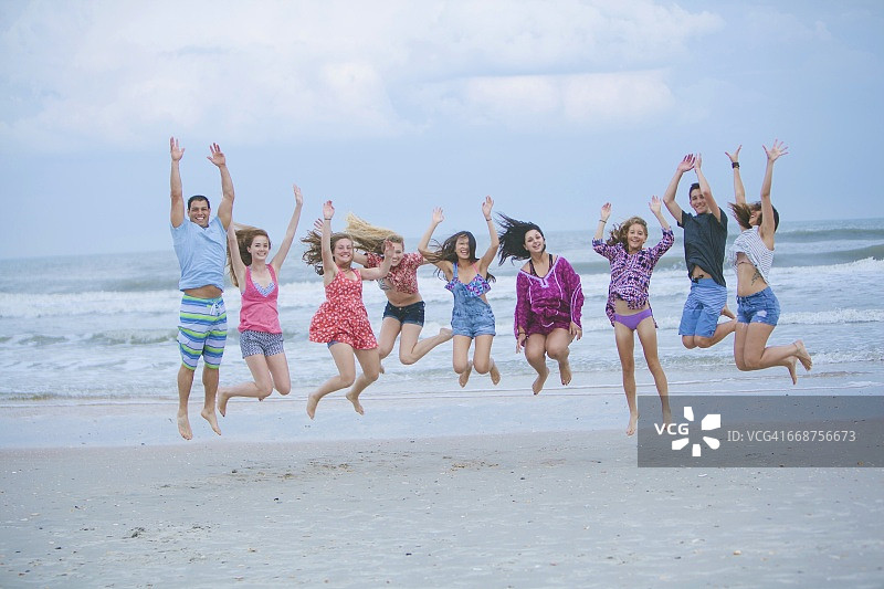 一群朋友在海滩上嬉戏跳跃图片素材
