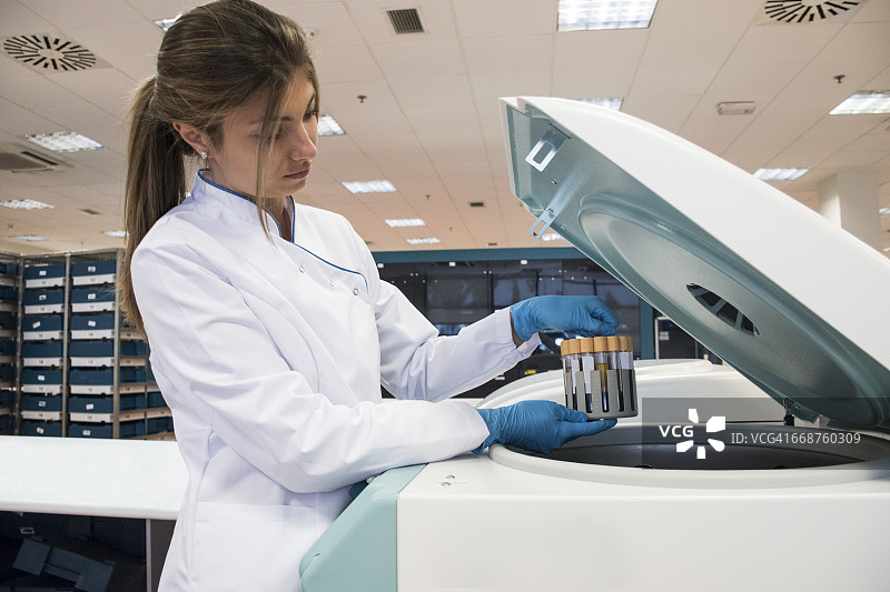 分析实验室技术员从离心机中取出试管图片素材