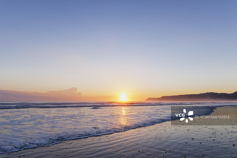 新西兰北岛日出时分的蒂阿拉罗瓦海湾海滩图片素材
