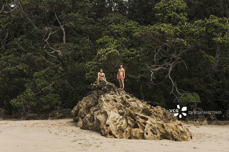 新西兰海滩上大岩石上的两个朋友图片素材