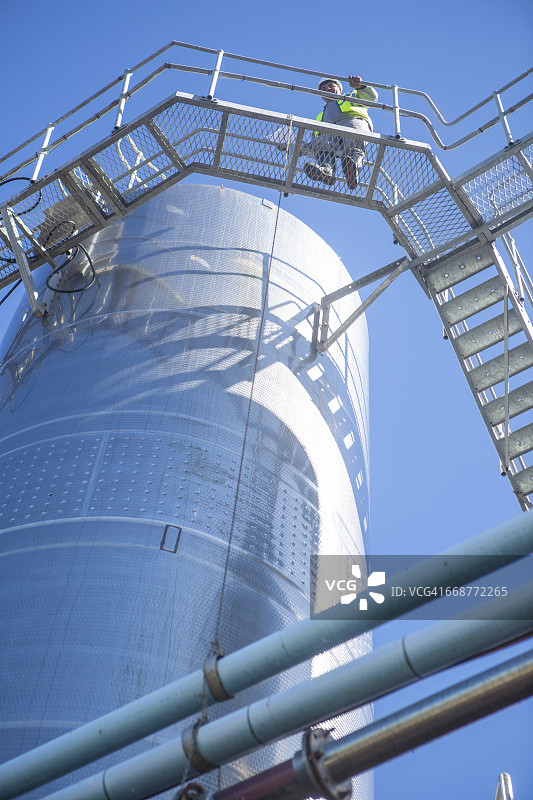 工人在食品工业中操作不锈钢罐图片素材