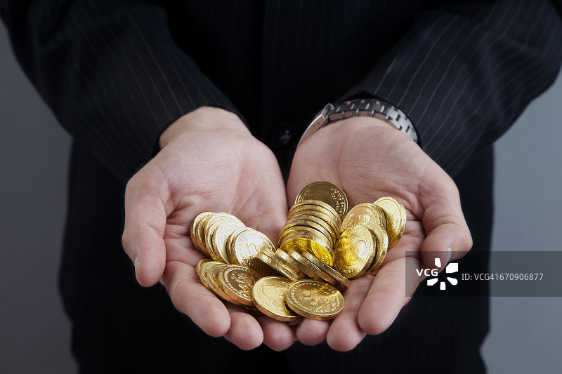 商务人士手持硬币特写图片素材