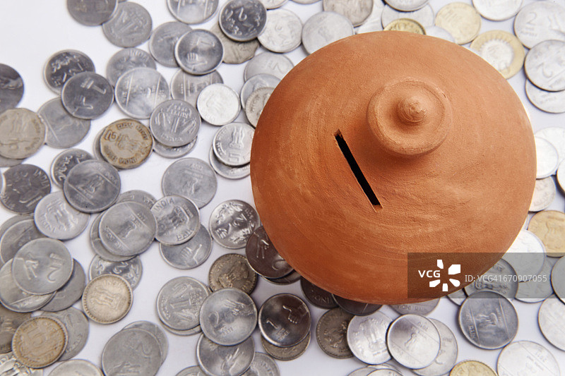 站在硬币堆上的粉色小猪存钱罐图片素材