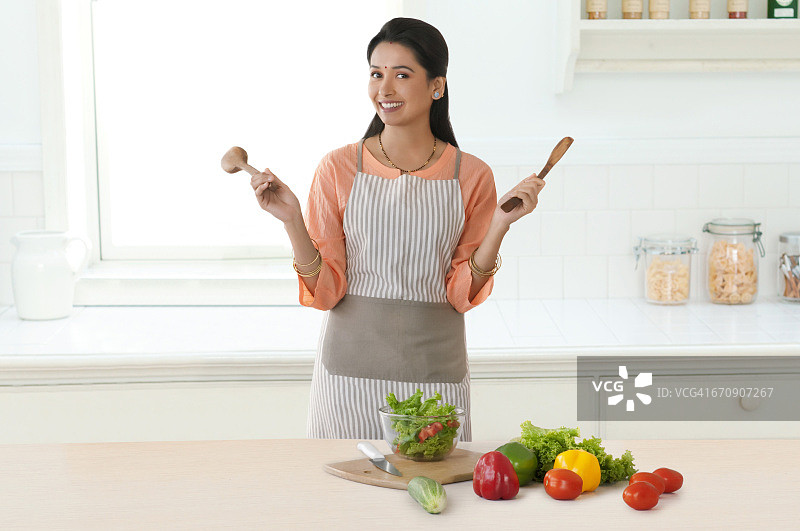 女人在厨房手持木制锅铲图片素材