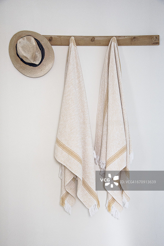 浴室墙壁挂钩上悬挂的毛巾图片素材