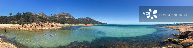 人们在僻静海湾清澈水中游泳图片素材