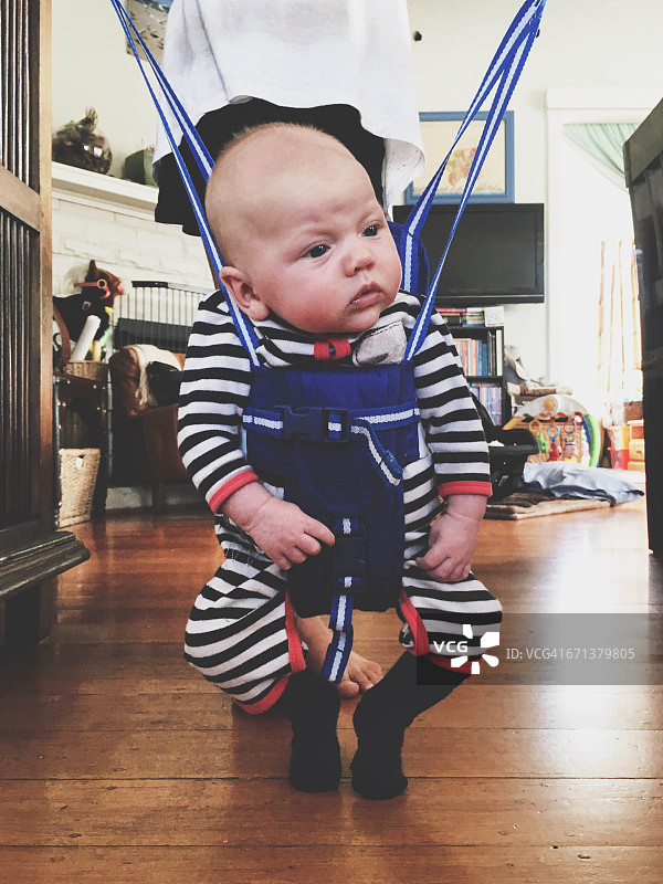 婴儿站在婴儿健身玩具里图片素材