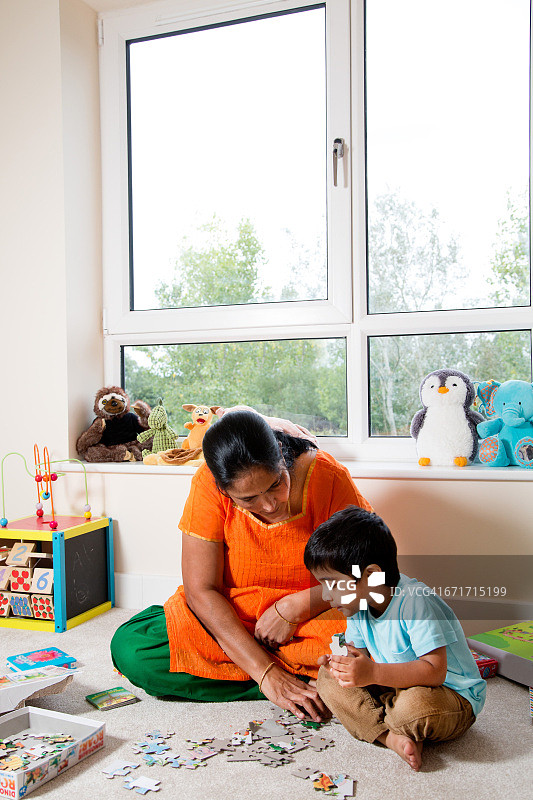 小男孩和奶奶一起拼图图片素材