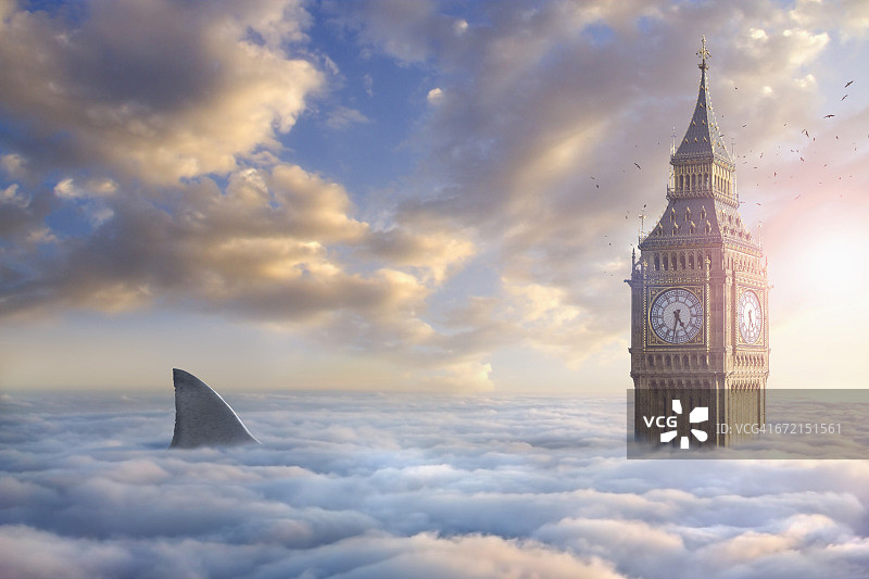 鸟儿在云层之上鲨鱼鳍附近的钟楼周围飞翔图片素材