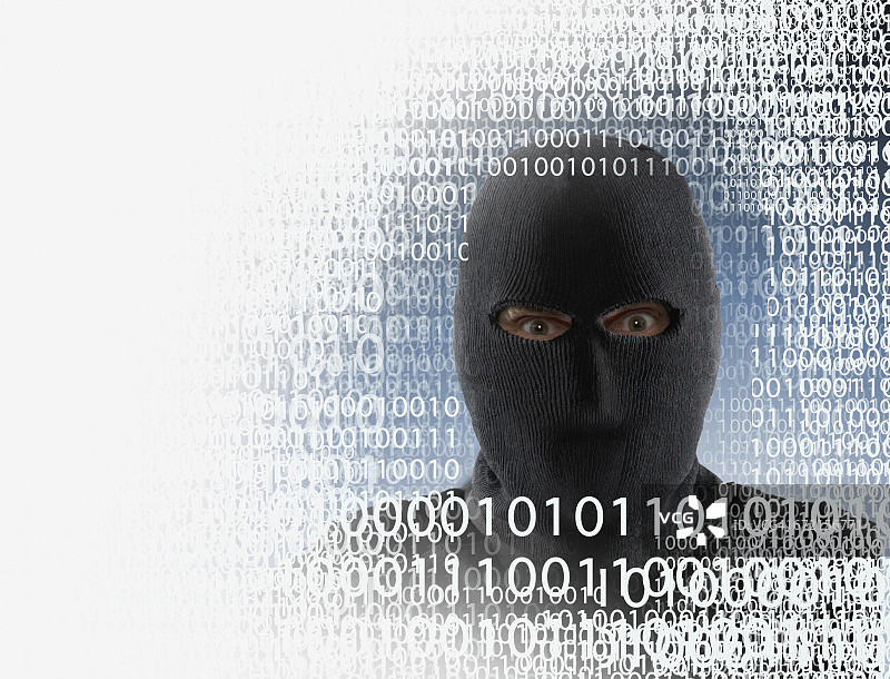 戴着面具的黑客在二进制代码中图片素材