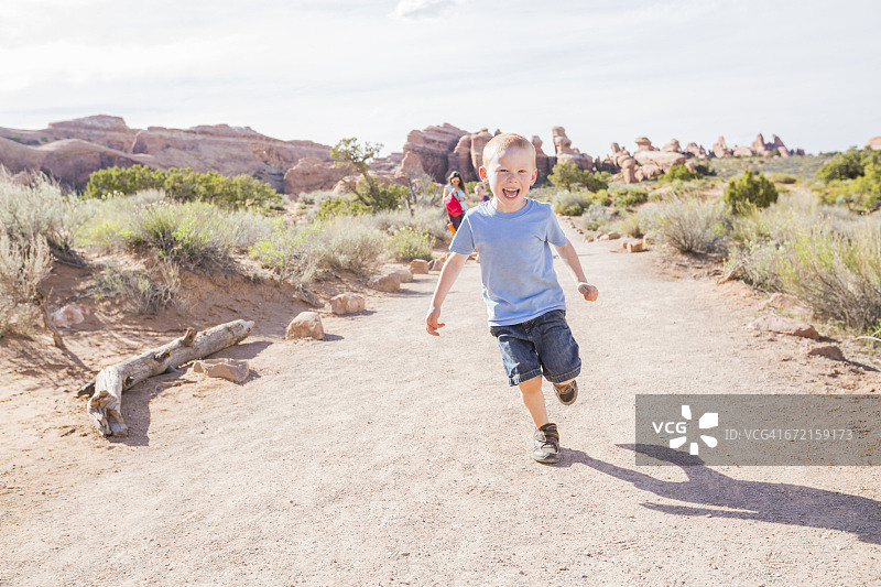 白人男孩在泥土路上跑步图片素材