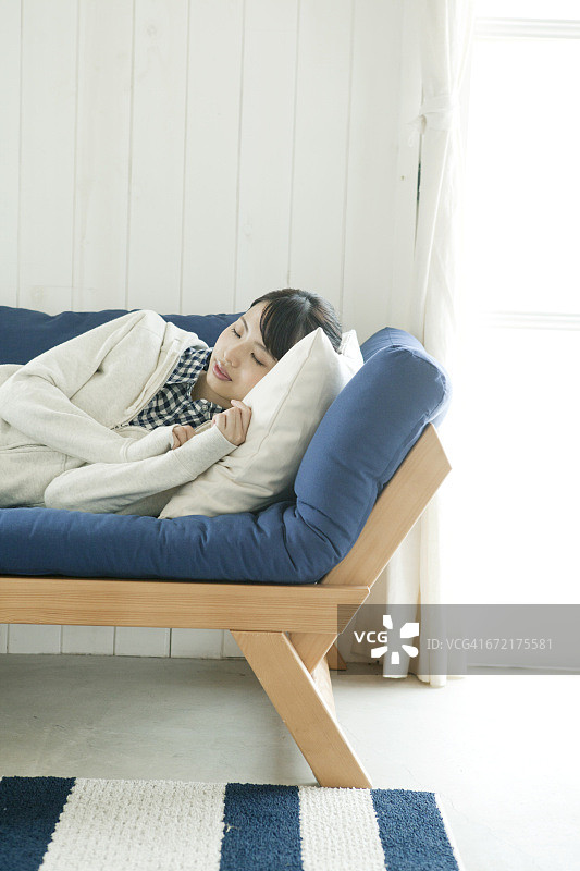 年轻女子在沙发上睡觉图片素材