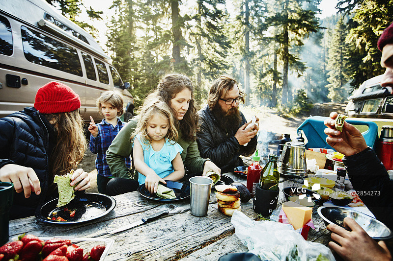 在露营时吃早餐的家人和朋友图片素材