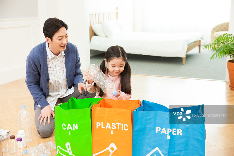 父女进行垃圾分类回收图片素材