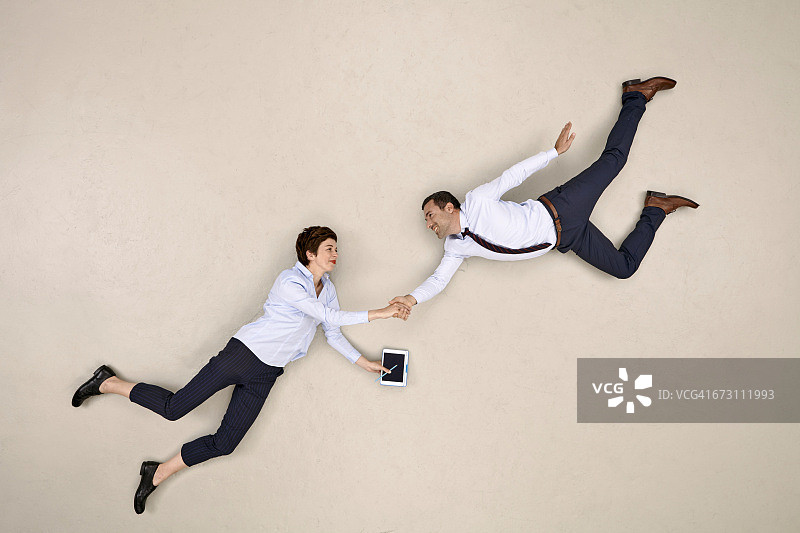 两位商务同事飞翔并握手图片素材