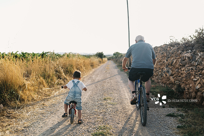 小男孩和曾祖父的自行车之旅（背影）图片素材