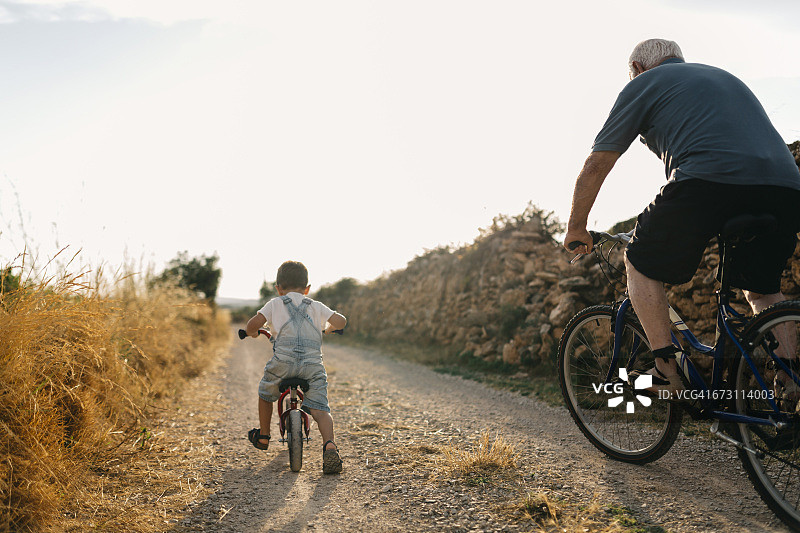 小男孩和曾祖父的自行车之旅（背影）图片素材