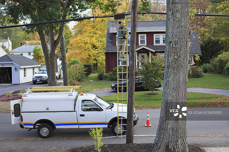 线路工人爬上梯子维修电线杆上的电缆图片素材