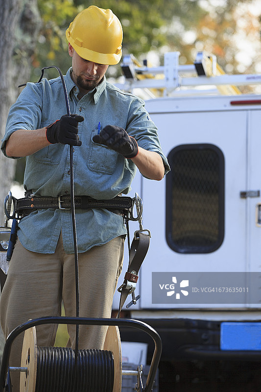 电缆线务员在现场从卷轴上拉电缆图片素材