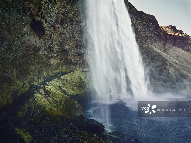 男人在冰岛拍摄瀑布图片素材