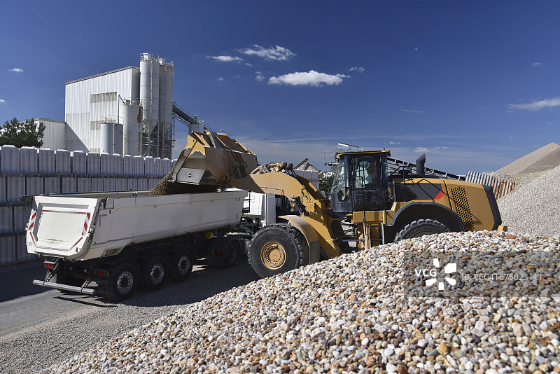 轮式装载机往卡车上装载砾石图片素材