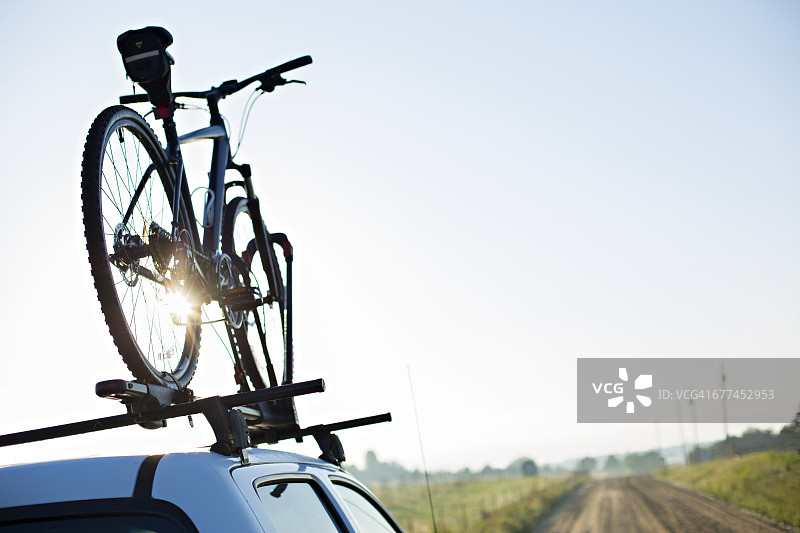 泥泞道路上卡车顶部的山地自行车图片素材