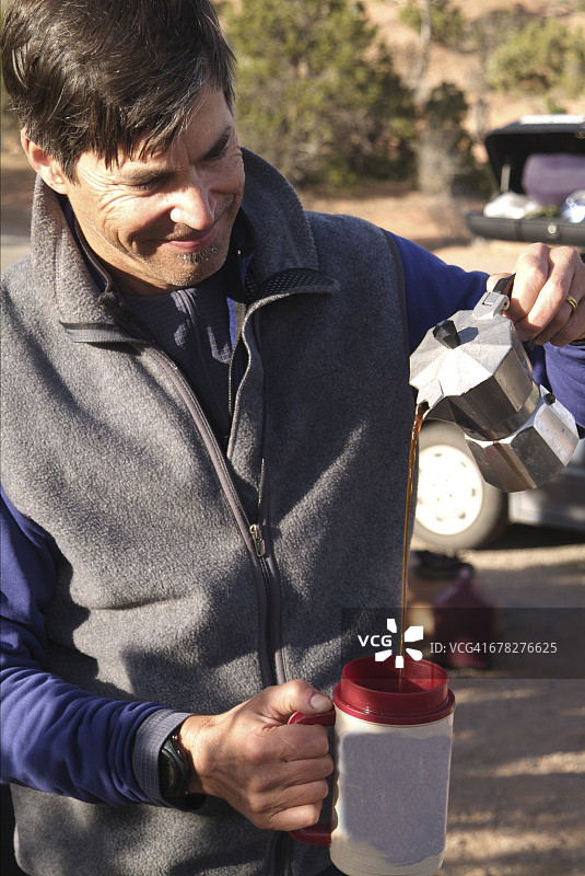 男人在露营时倒咖啡图片素材