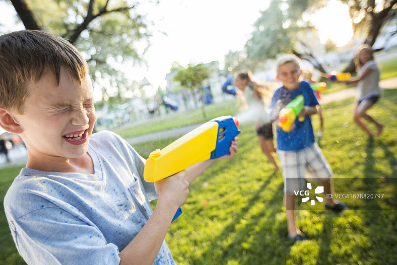 白人男孩和女孩玩水枪图片素材