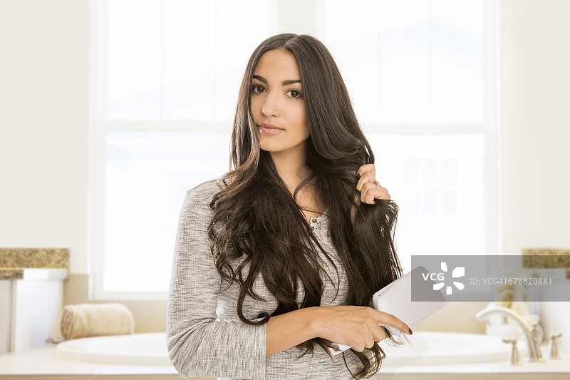 在浴室里梳头的混血女人图片素材