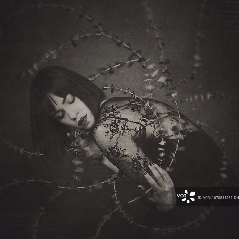 黑色连衣裙女子与缠绕藤蔓图片素材