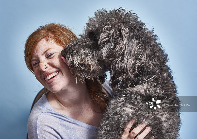 和她的狗在一起的红发英国女人图片素材