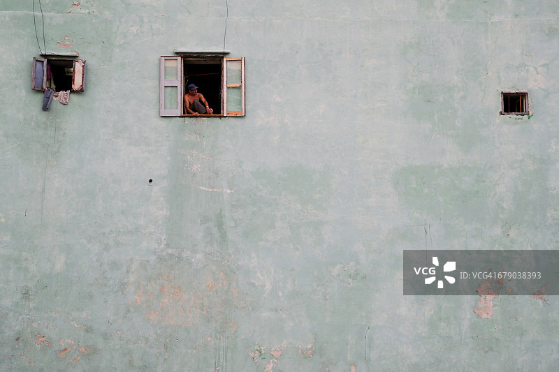 在古巴哈瓦那，男子望向窗外图片素材