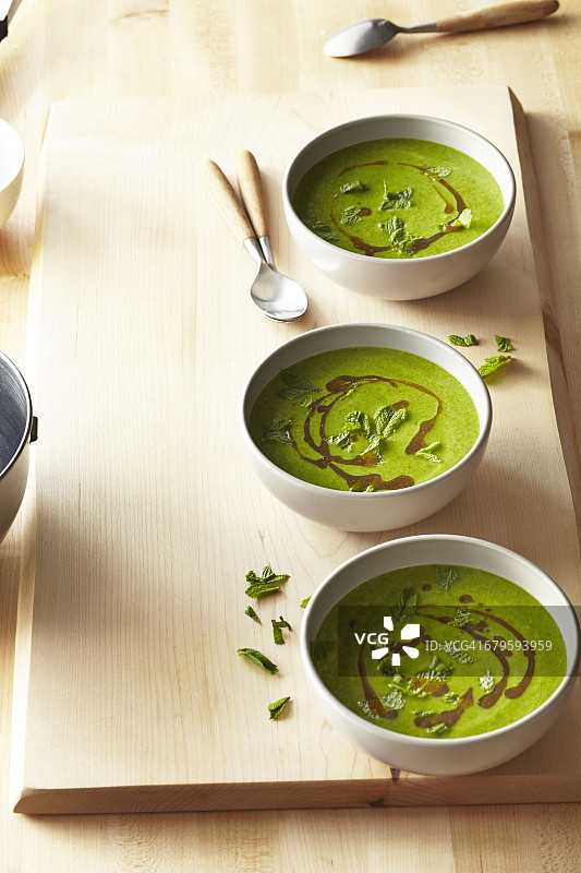 三碗木制表面的菠菜汤图片素材