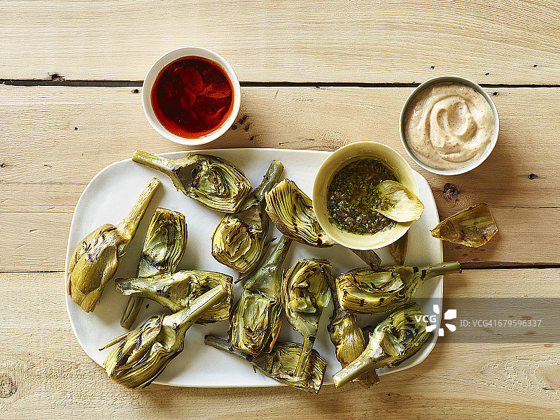 烤朝鲜蓟配三种酱汁的俯视图图片素材