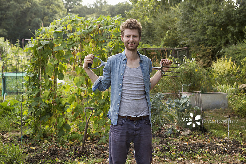 园丁站在带有园艺工具的分配地上图片素材