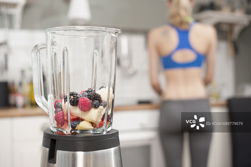 巴伐利亚厨房：搅拌机与水果，背景为年轻女性图片素材