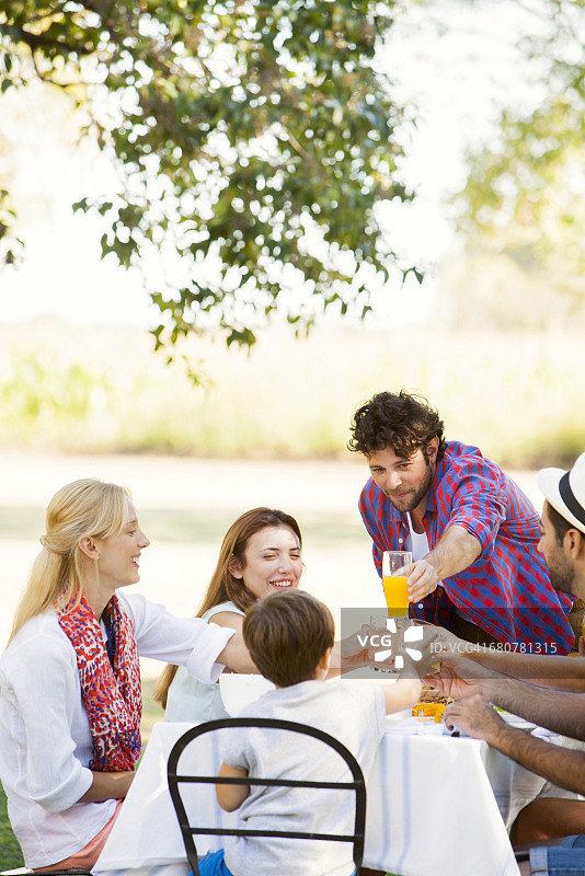 朋友们在户外一起用餐时碰杯图片素材