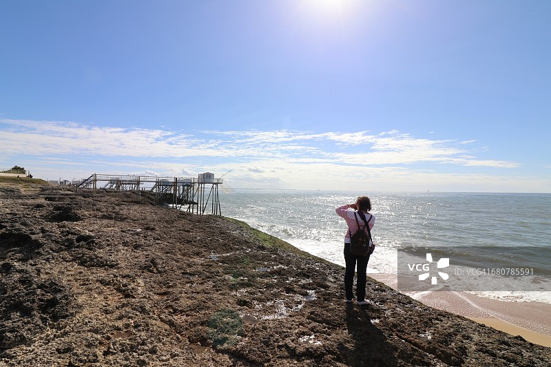 在法国罗什福尔圣帕莱-叙尔-梅尔海滩上拍照的女人图片素材