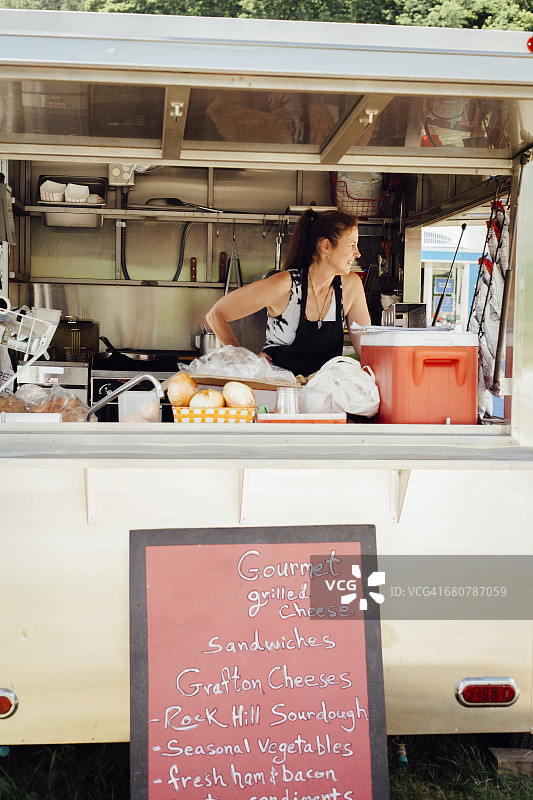 女人从食品摊位车里向外看图片素材