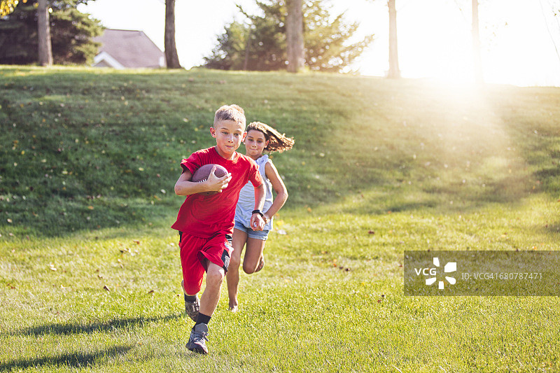 玩美式橄榄球的女孩和男孩图片素材