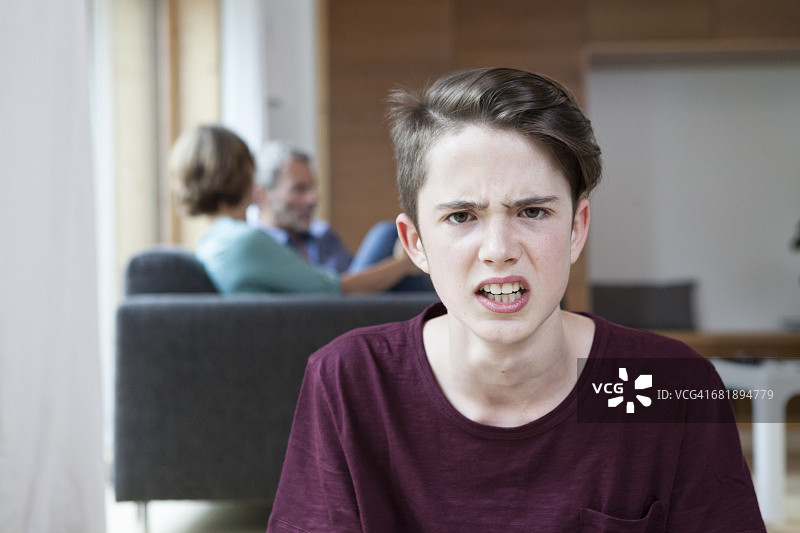 在家中与父母争吵的愤怒少年肖像图片素材