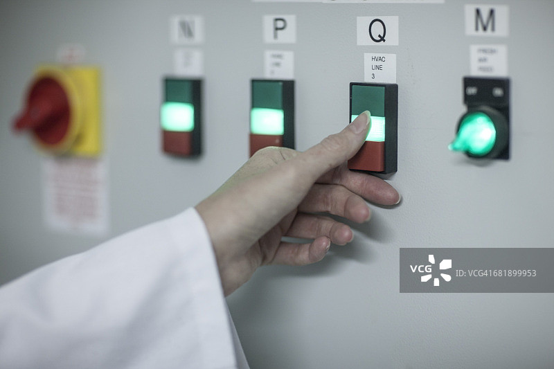 在工厂里打开电源开关的女人特写图片素材