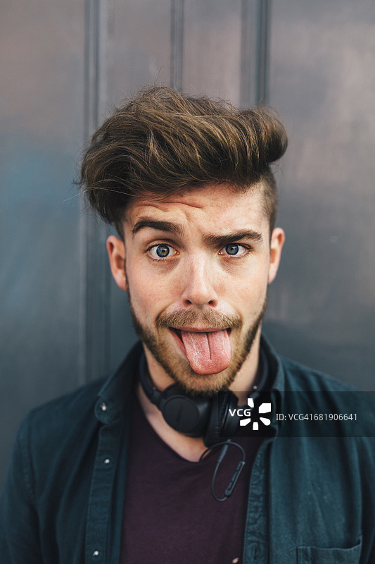 吐舌头的年轻男子肖像图片素材