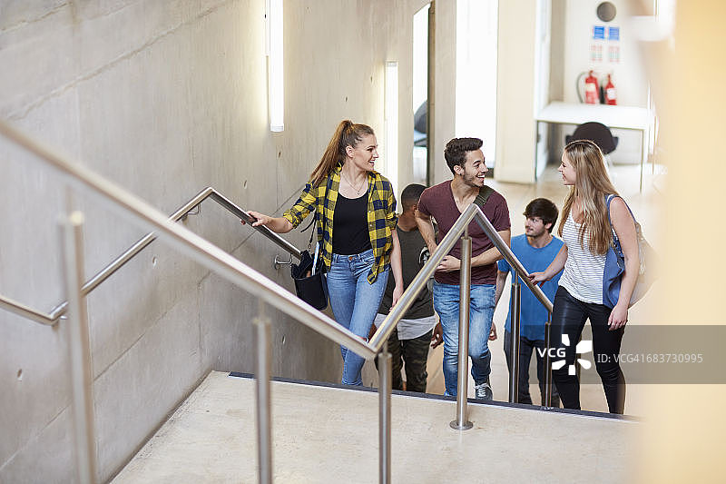 一群大学生在高等教育学院的楼梯上行走图片素材